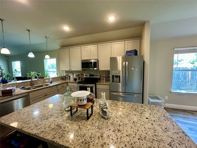 Kitchen with appliances with stainless steel finishes, light stone countertops, healthy amount of natural light, wood finished floors, and recessed lighting | Image 13