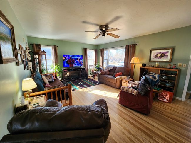 Living room with a ceiling fan, a wealth of natural light, and wood finished floors | Image 16