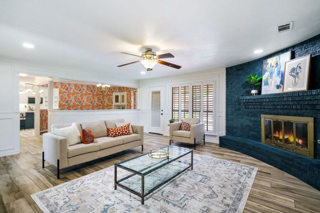 Living room featuring a decorative wall, ceiling fan, a brick fireplace, wood finished floors, and recessed lighting | Image 11
