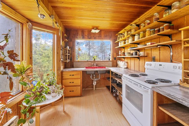 Kitchen featuring electric range, open shelves, wooden ceiling, a sink, and light countertops | Image 6