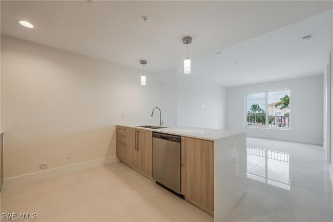 Kitchen featuring a peninsula, light countertops, a sink, modern cabinets, and dishwasher | Image 19