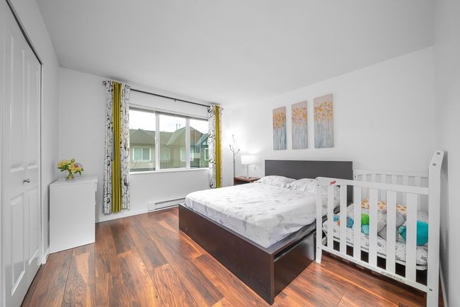 Bedroom with a closet, a baseboard radiator, and wood finished floors | Image 24