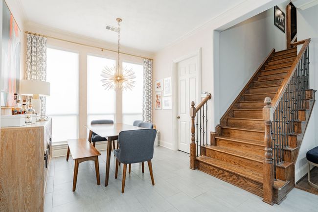 Dining space featuring ornamental molding, a notable chandelier, stairs, and visible vents | Image 12