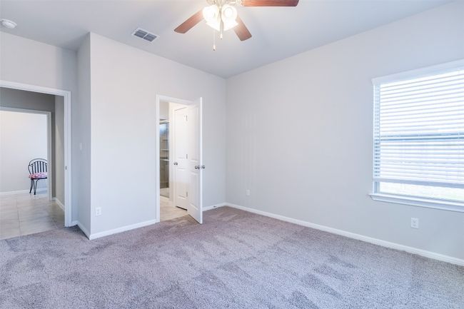 Unfurnished bedroom featuring visible vents, baseboards, carpet, and ceiling fan | Image 25