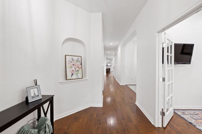 Hall featuring dark wood-style flooring, recessed lighting, and arched walkways | Image 6