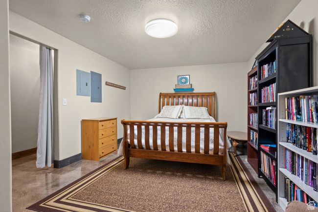 Bedroom featuring electric panel, baseboards, and a textured ceiling | Image 25
