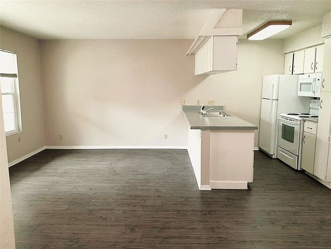 Side view from hallway of kitchen and living room | Image 6