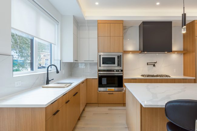 Kitchen with a sink, range hood, stainless steel appliances, and modern cabinets | Image 6