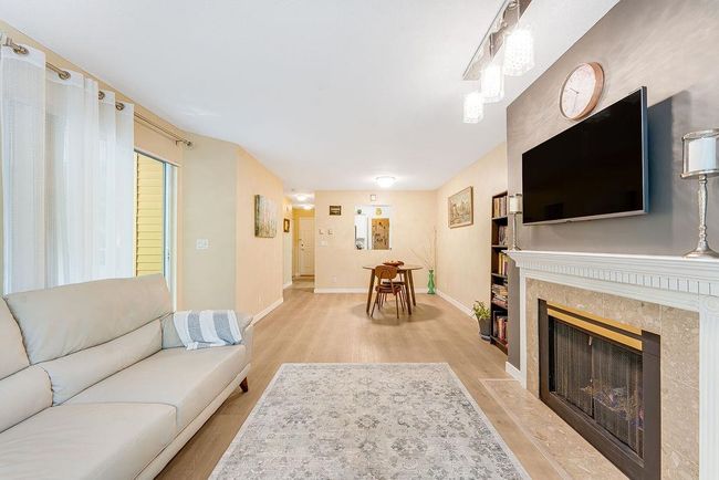Living room featuring light wood-style flooring, baseboards, and a high end fireplace | Image 24