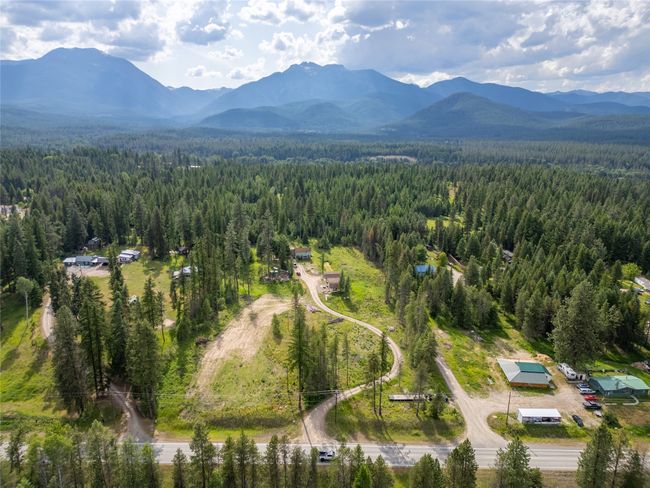 Aerial view of property and surrounding area featuring a forest and a mountainous background | Image 24