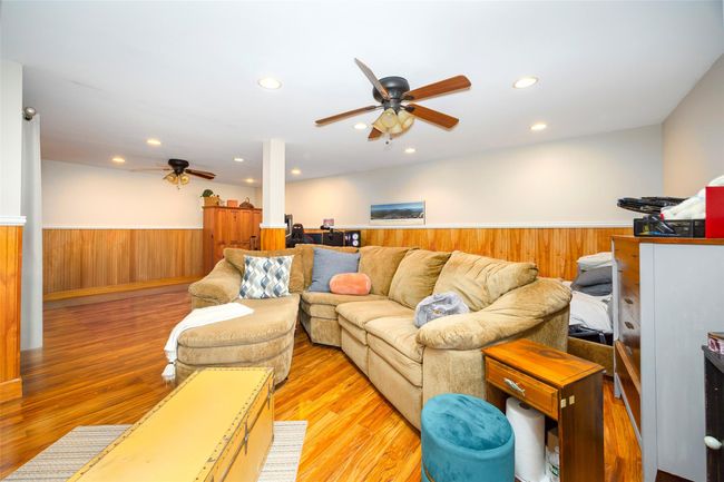 Living area featuring ceiling fan, a wainscoted wall, light wood-style flooring, recessed lighting, and wooden walls | Image 24
