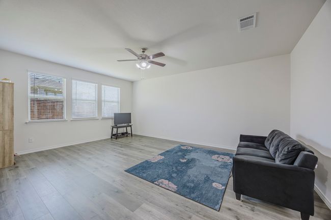 Living area with a ceiling fan and wood finished floors | Image 12