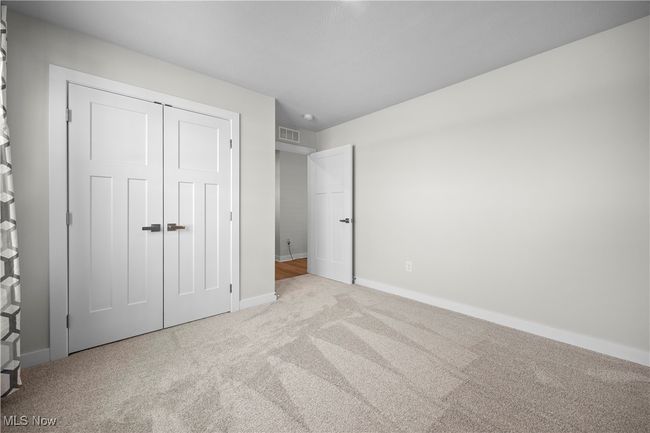 Unfurnished bedroom featuring visible vents, baseboards, carpet flooring, and a closet | Image 8
