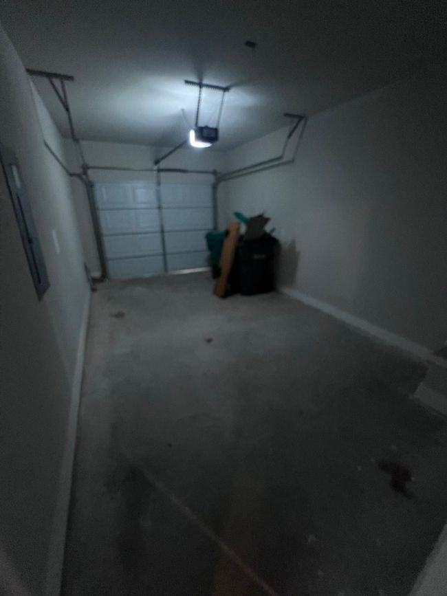 Garage with a garage door opener, baseboards, and electric panel | Image 18