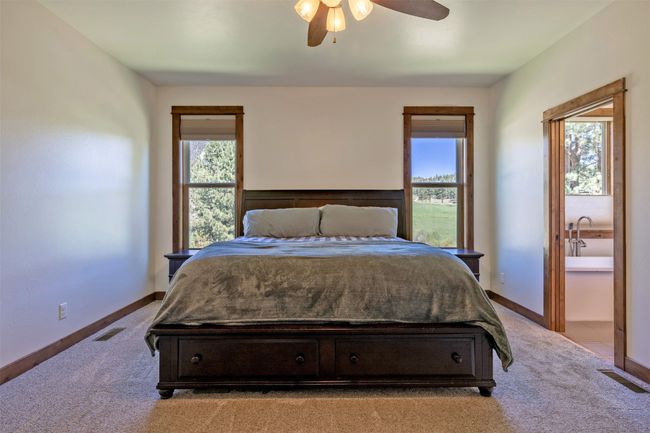 Bedroom featuring light carpet, ceiling fan, and baseboards | Image 17