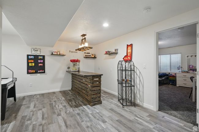 Interior space with wood finished floors, baseboards, and a dry bar | Image 32
