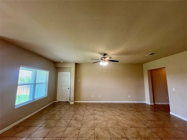 Family room featuring a ceiling fan and light tile patterned floors | Image 21