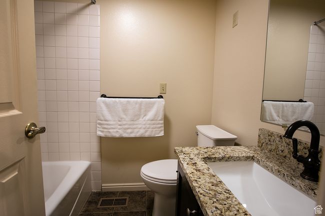 Full bath featuring toilet, vanity, tile patterned flooring, baseboards, and shower / bathtub combination | Image 17