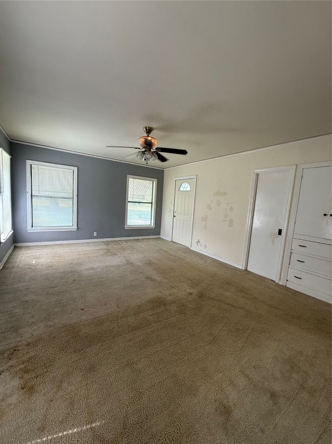 Carpeted empty room featuring ceiling fan and baseboards | Image 7