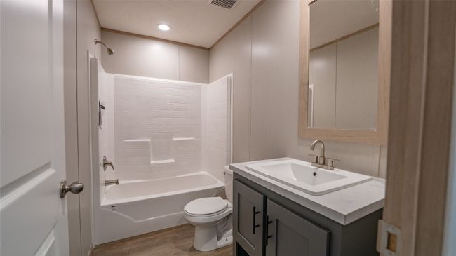 Full bathroom featuring vanity, wood finished floors, and shower / bath combination | Image 17