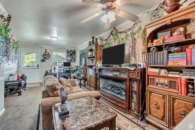 Living room with light carpet, ceiling fan, a desk, and ornamental molding | Image 6