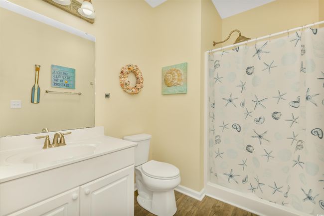 Bathroom featuring wood finished floors, vanity, toilet, a shower with curtain, and baseboards | Image 18