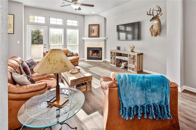 Living room with ceiling fan, wood-type flooring, and vaulted ceiling | Image 13