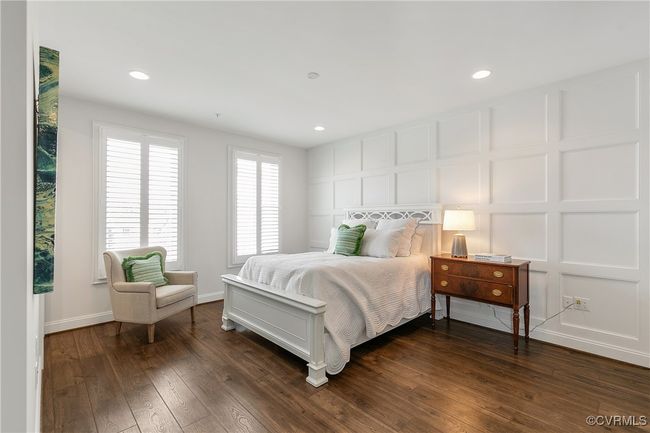 Bedroom featuring a decorative wall, dark wood finished floors, and recessed lighting | Image 19
