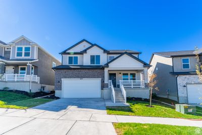 View of front of property featuring a garage, a front lawn, and a porch | Image 1