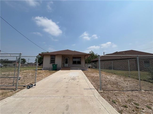 View of front facade featuring fence, concrete driveway, and stucco siding | Image 10