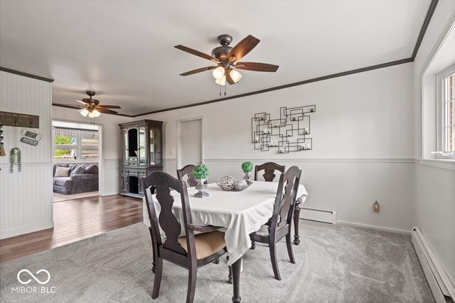 dining space featuring baseboard heating, a ceiling fan, a baseboard heating unit, baseboards, and ornamental molding | Image 21