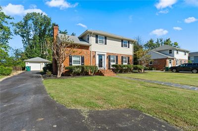 View of front facade featuring a garage, an outdoor structure, and a front lawn | Image 2