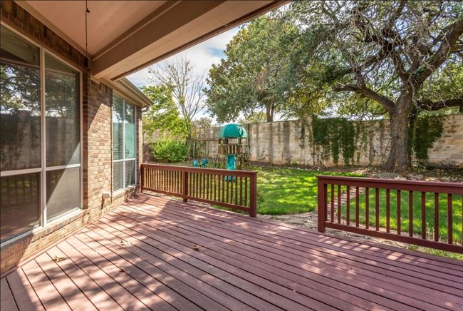 Wooden deck featuring a fenced backyard, a yard, and a playground | Image 27