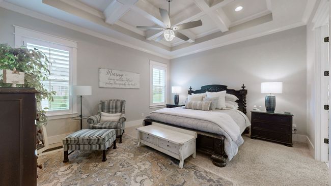 Retreat to this stunning primary suite featuring a coffered ceiling, soft natural light, and a calming color palette—creating the perfect space to rest, recharge, and unwind in total comfort. | Image 27