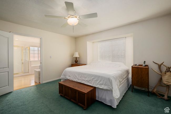 Carpeted bedroom with connected bathroom and a ceiling fan | Image 23