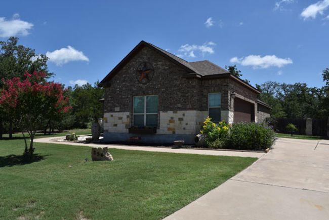 View of front facade with driveway, a garage, and brick siding | Image 35