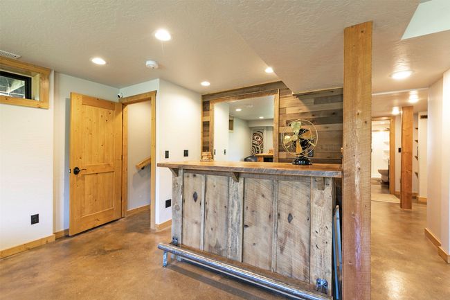 Indoor dry bar featuring finished concrete flooring, baseboards, a textured ceiling, and recessed lighting | Image 31