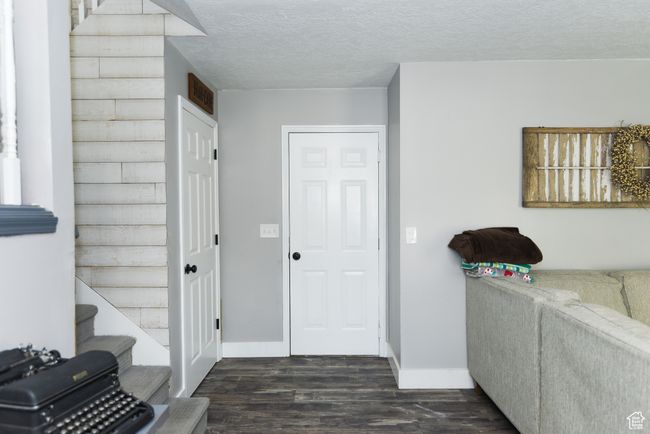 Entrance foyer featuring a textured ceiling, baseboards, and dark wood-type flooring | Image 23