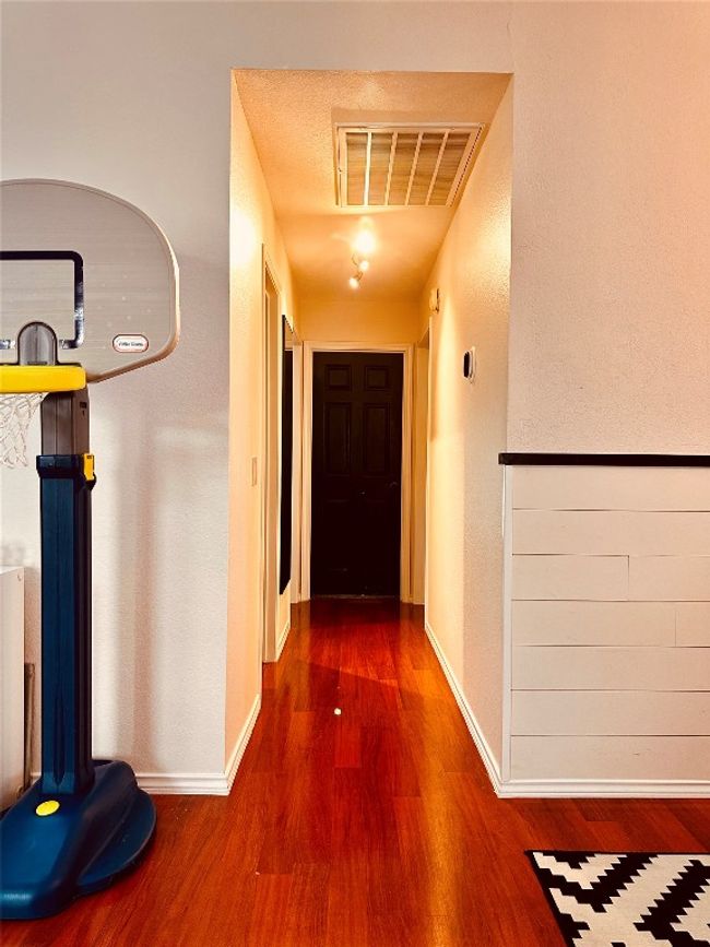 Hallway featuring visible vents, baseboards, and wood finished floors | Image 16
