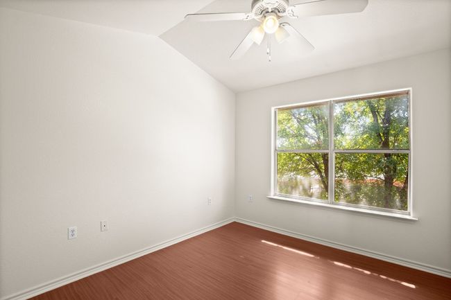 Unfurnished room featuring wood finished floors, ceiling fan, and vaulted ceiling | Image 9