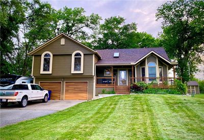 Split level home featuring a garage, a front yard, and a porch | Image 1