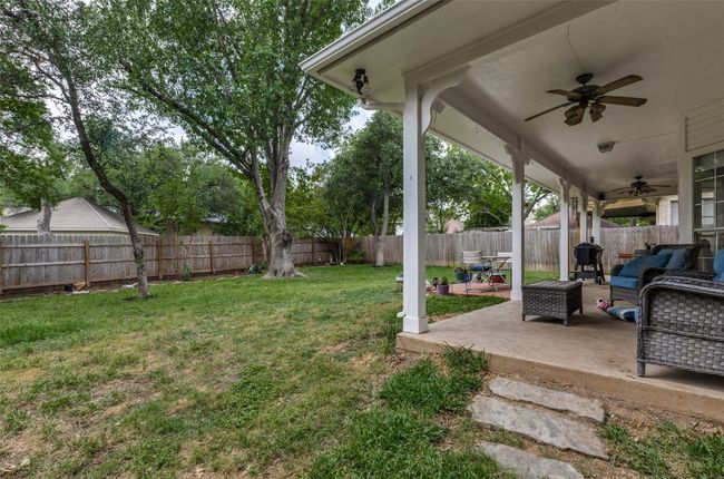 Another living space outdoors is this huge covered patio across the entire back of home overlooks this large, , privacy-fenced backyard with lots of shade & trees for children, pets, bakyard barbecues, or just ejoying a cup of coffee in your own private oasis or cocktails in the evening. Quiet, peacful, you would never know you were so close to EVERYTHING including downtown Austin and the beautiful hill country. | Image 33
