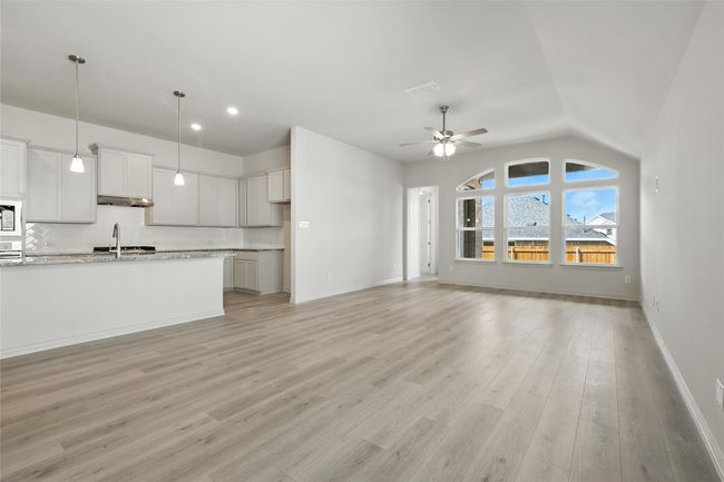 Unfurnished living room featuring a ceiling fan, light wood-type flooring, vaulted ceiling, and recessed lighting | Image 10