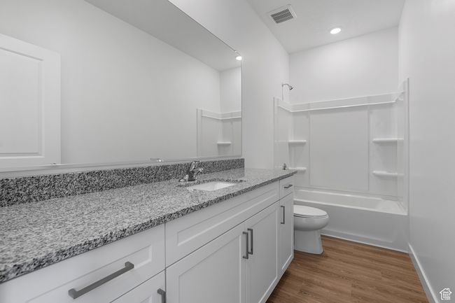 Full bath with toilet, wood finished floors, shower / tub combination, visible vents, and vanity | Image 8