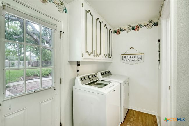 Laundry room downstairs with a door leading to the backyard. | Image 17
