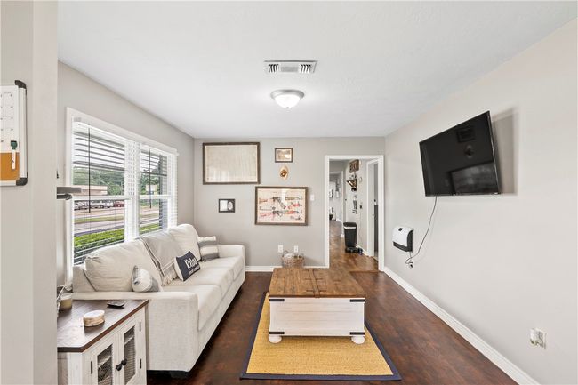Living room with dark wood-type flooring and baseboards | Image 8