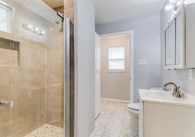 Bathroom featuring toilet, marble finish floor, a shower stall, and vanity | Image 10