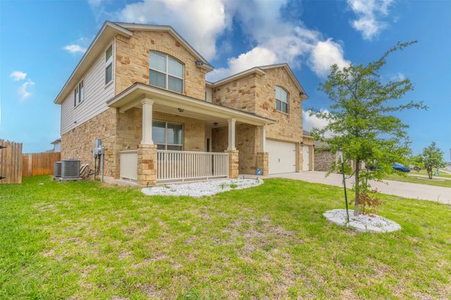 Traditional-style house with fence, a front lawn, stone siding, a garage, and a porch | Image 32