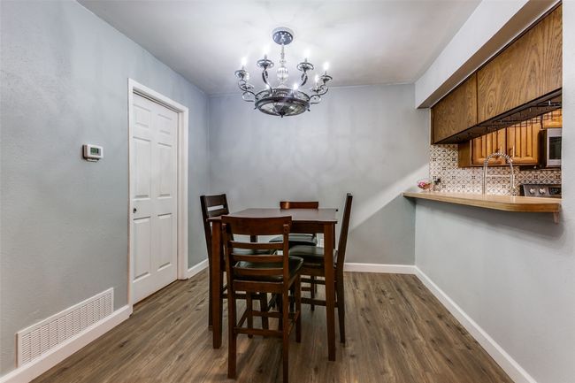 Dining space featuring a fandelier and dark wood-type flooring | Image 13
