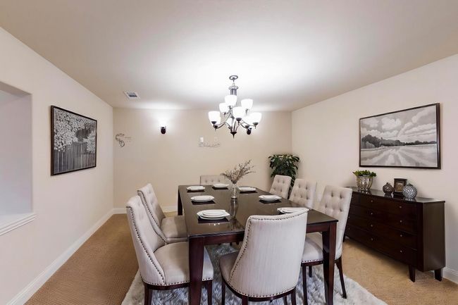 Dining space with light carpet, a chandelier, and baseboards | Image 6